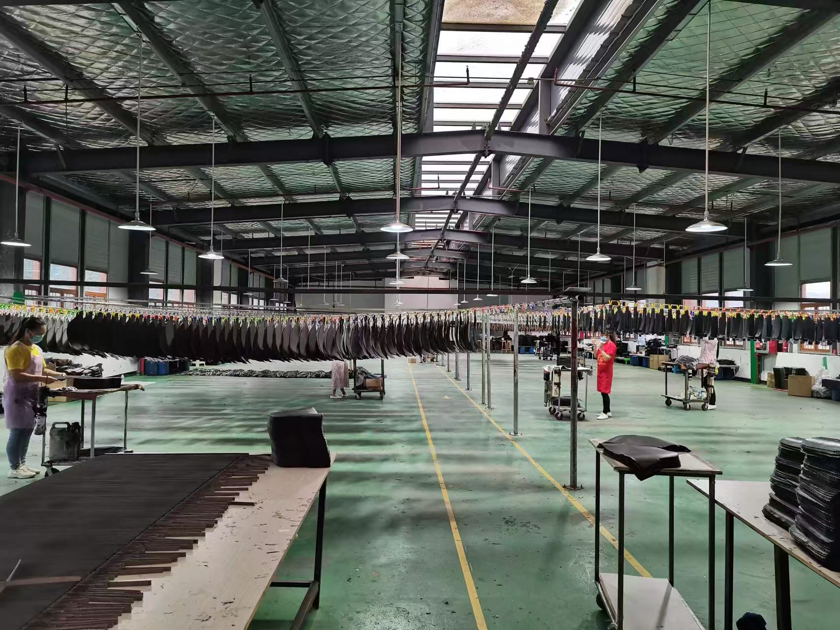 Edge painting workshop with rows of straps on drying lines