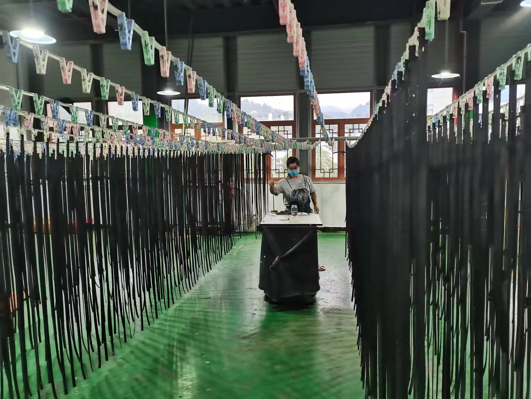 Worker performing detailed edge painting on leather straps